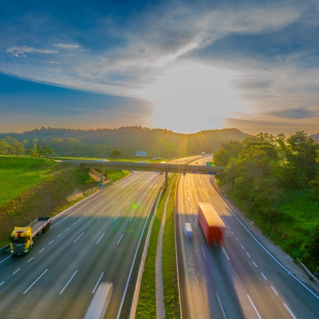 Foto de um trecho de rodovia com pôr do sol ao fundo